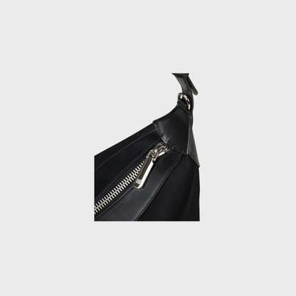 Black leather bag with a silver zipper on a light gray background