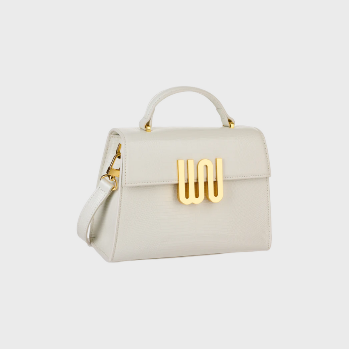 White handbag with gold hardware on a light gray background