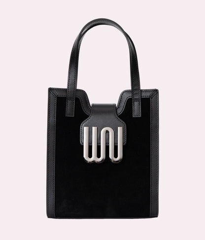 Black tote bag with a unique metal clasp on a light gray background