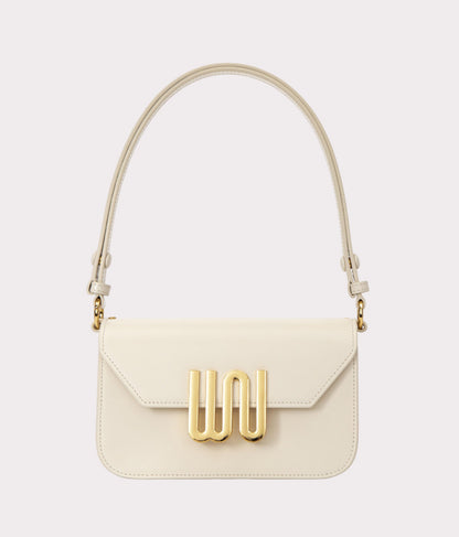White handbag with gold accents on a light gray background