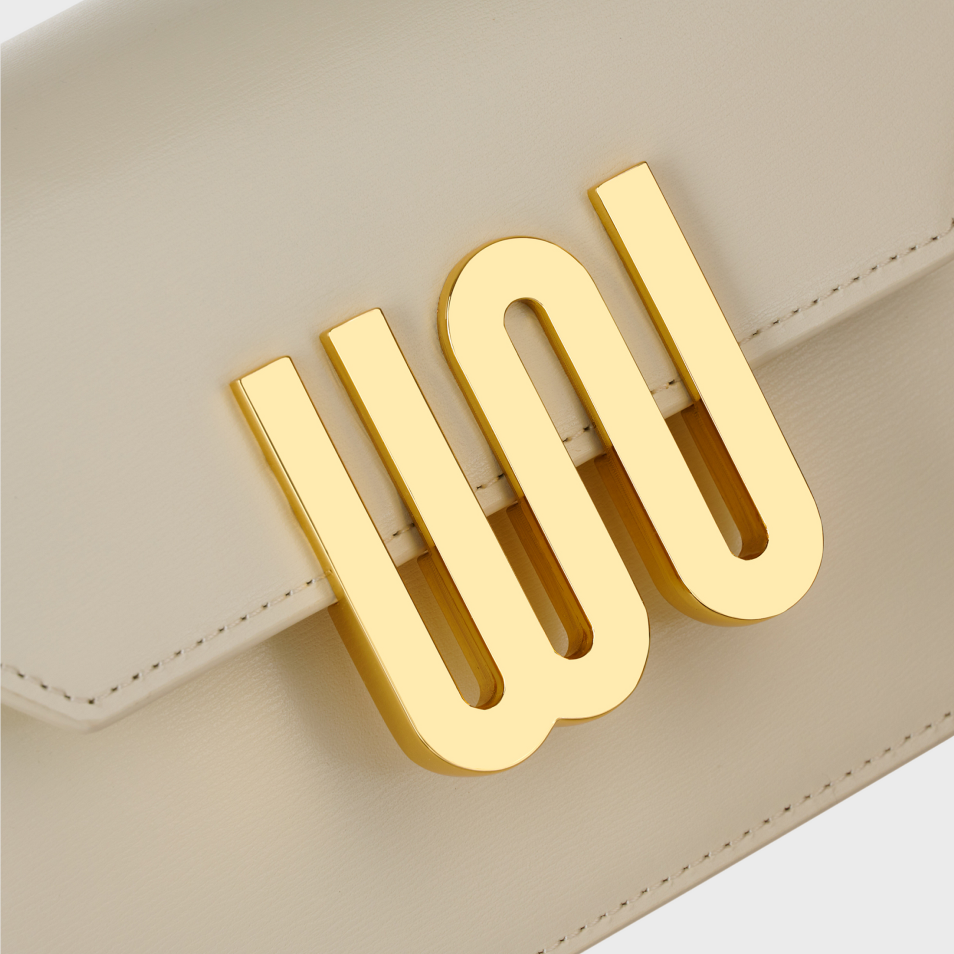 Beige handbag with gold clasp on a light gray background