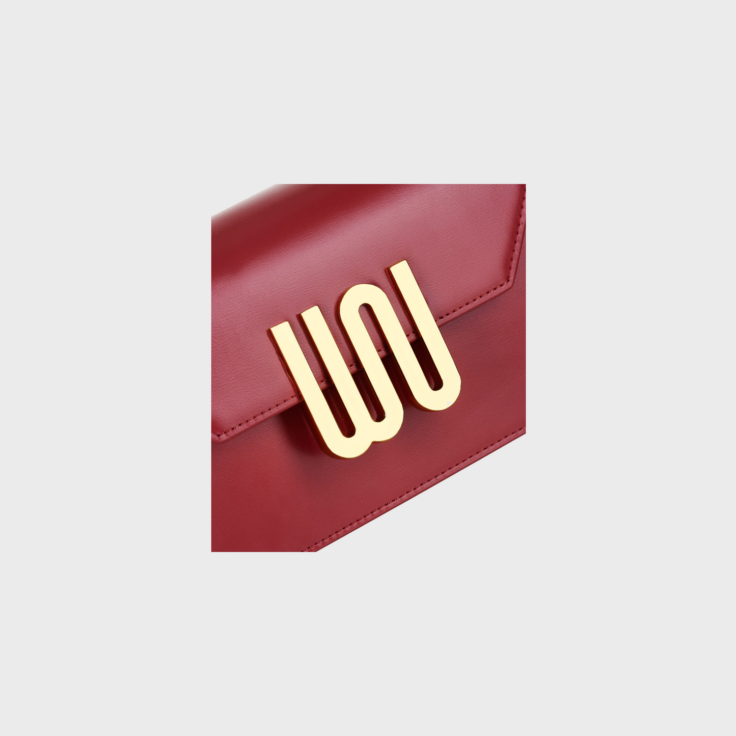 Red handbag with a gold logo on a light gray background