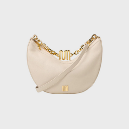 Beige handbag with gold chain detail on a light gray background