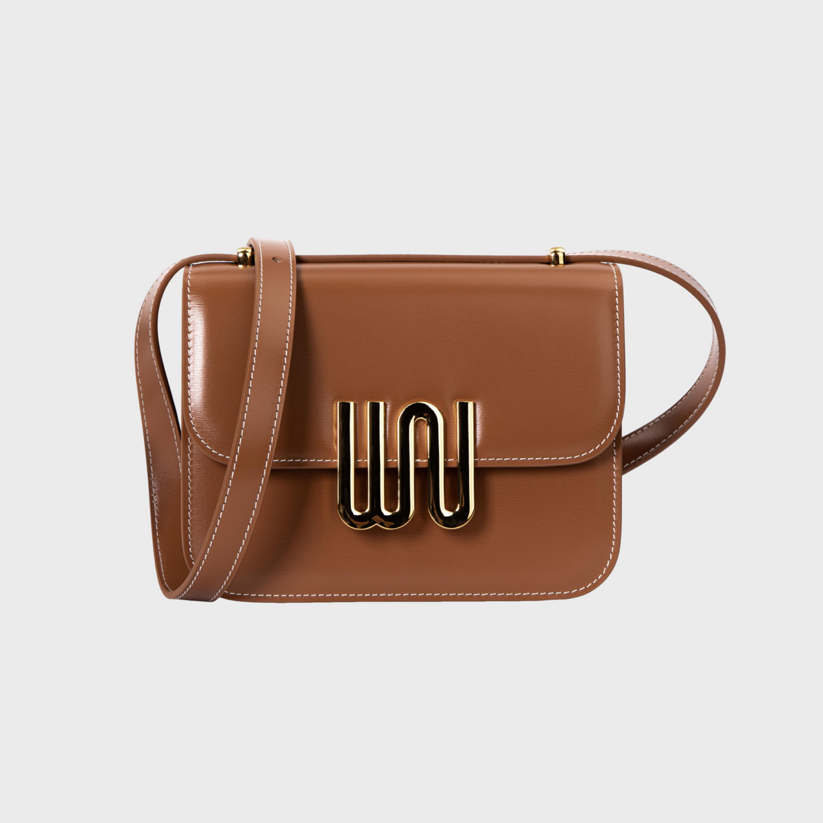 Brown handbag with a gold clasp on a light gray background