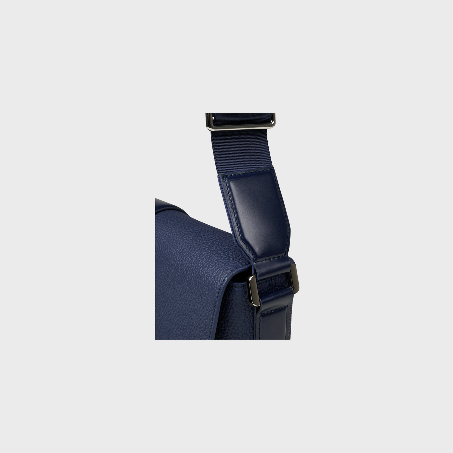 Navy blue backpack with a strap on a light gray background