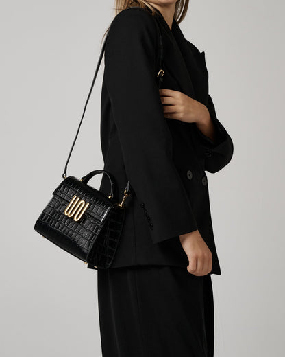 Bronzite Noir worn crossbody over a black suit