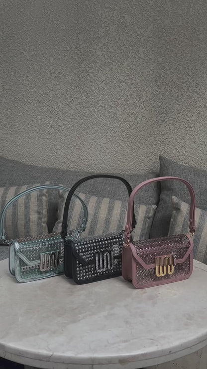 Amber statement crossbody bag in soft rose, black & mint color with all-over crystal embellishment, one-piece leather construction, and transformative versatility.