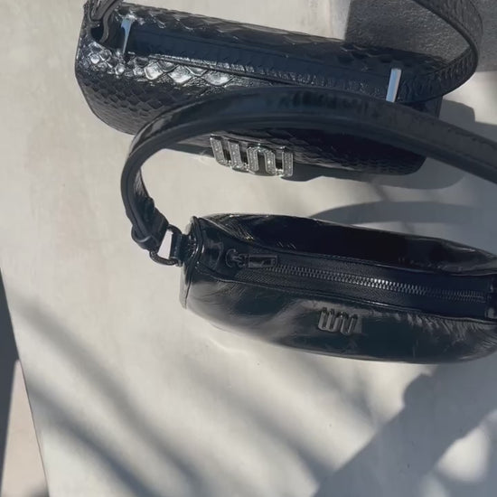 A refined selene black shoulder bag with hand-cut python-embossed leather and transformative versatility.