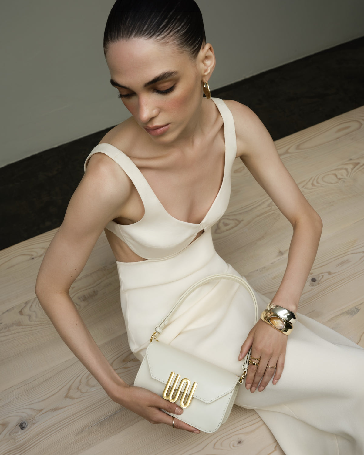 Garnet Nougat held in her lap, ivory dress, pale wood floor
